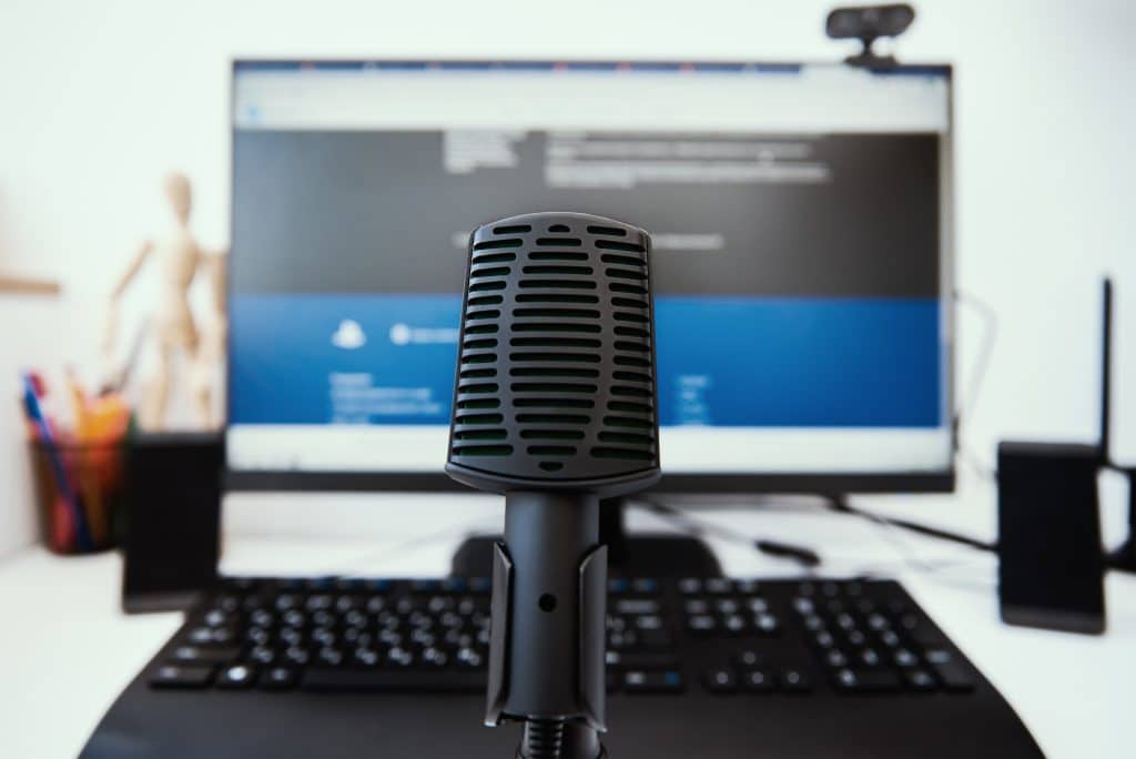 A microphone on a desk in front of a computer